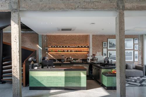 an open kitchen with a brick wall at Lilit Bang Lumphu Hotel in Bangkok