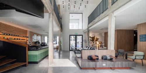 a lobby of a restaurant with a table and chairs at Lilit Bang Lumphu Hotel in Bangkok