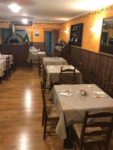 a row of tables in a restaurant with white tablecloths at Locanda Aquila Nera in Aquiléia