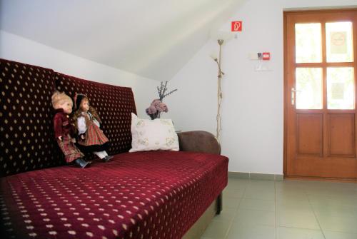 two children are standing on a couch with a red blanket at Vendégház a Csabay Kúriához in Lakitelek