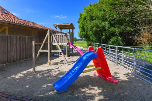 a playground with a plastic slide and a slideintend at Ferienwohnung Mühlenblick auf dem Ferienhof Eschen in Moorweg