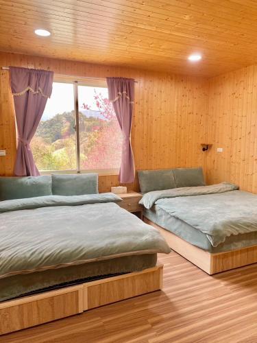 sypialnia z 2 łóżkami i oknem w obiekcie Temu 鐵木蘭農場 w mieście Gauyi