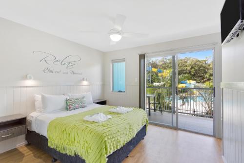 1 dormitorio con 1 cama y balcón en Nobby Beach Holiday Village, en Gold Coast