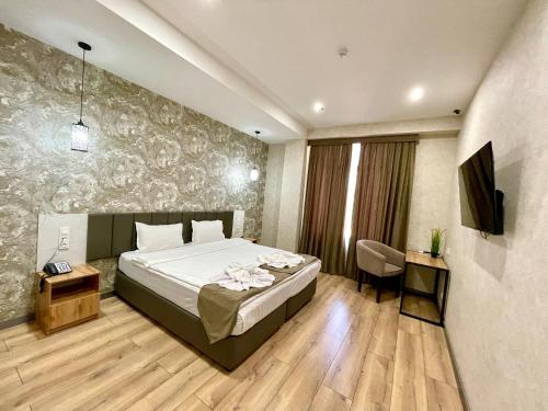 a bedroom with a bed and a television in a room at Alpha Plaza Hotel & SPA in Tashkent
