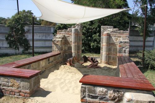 a person laying in the sand in a sandbox at Thermál Apartmanház in Komárom