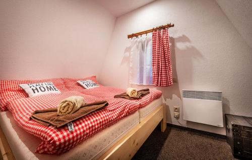 a bedroom with a bed with towels and a window at Chata Smrekovica in Liptovský Ján