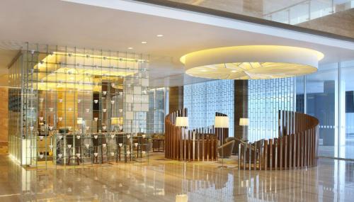 a lobby with chairs and tables in a building at DoubleTree by Hilton Jakarta Kemayoran in Jakarta