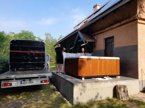 two people standing on the back of a truck with a hot tub at Vendégház a Csabay Kúriához in Lakitelek