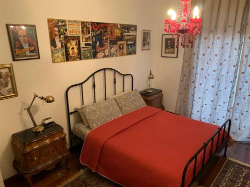 a bedroom with a red bed and a chandelier at B&BMagicHouse in Novara