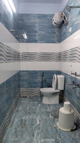 a bathroom with a toilet and a sink at Gokulam Holiday Home in Munnar