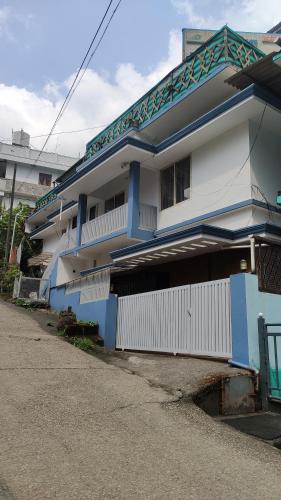 a blue and white building next to a street at Gokulam Holiday Home in Munnar