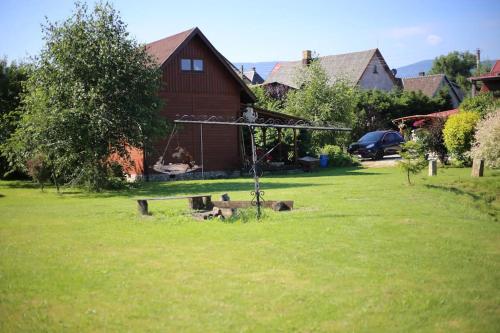 a swing in a yard next to a house at Karkonoska Chatka in Mysłakowice