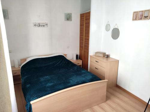 1 dormitorio con 1 cama con manta verde en Confortable maison de village en pierre typique, en Moltig les Bains