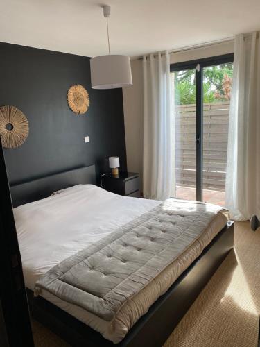 a bedroom with a large bed and a window at Au cœur de la Pinède de 1 à 4 personnes in Langlade