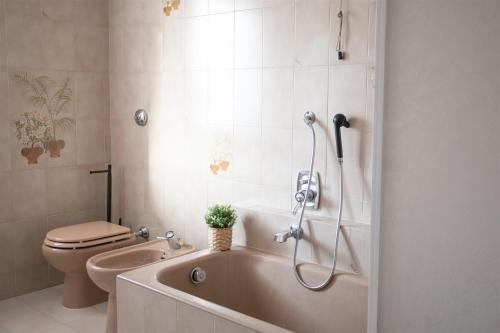 a bathroom with a bath tub and a toilet at IseoLakeRental - Appartamento Livio in Solto Collina