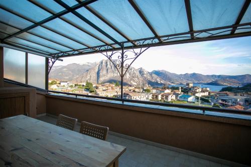 a table and chairs in a room with a large window at IseoLakeRental - Appartamento Livio in Solto Collina