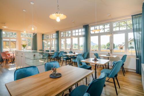 a restaurant with tables and chairs and windows at Waldidylle Gohrisch, Garni-Hotel, Sächsische Schweiz in Kurort Gohrisch