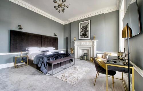een slaapkamer met een groot bed en een open haard bij The York Place Residence in Edinburgh