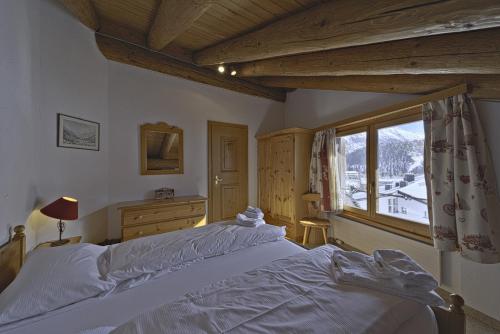 um quarto com uma cama grande e uma janela em Chesa Suvretta - Celerina em Celerina