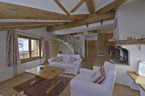 uma sala de estar com mobiliário branco e uma lareira em Chesa Suvretta - Celerina em Celerina