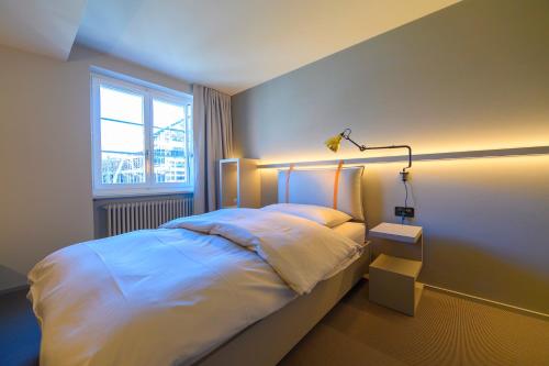 a bedroom with a bed with a light on it at Landhotel Linde Fislisbach in Baden