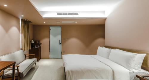 a bedroom with a bed and a table and a couch at Inns Hotel in Kaohsiung