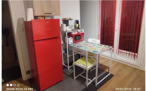 una piccola cucina con frigorifero rosso e tavolo di Studio pour Déplacements Professionnels- étudiant a Nevers
