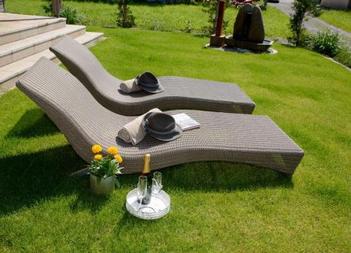 a bench with hats on it in the grass at Haus Sonne & SPA in Bizau