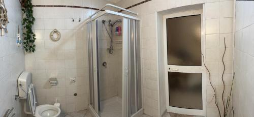 La salle de bains est pourvue d'une douche et de toilettes. dans l'établissement Artemide Home, à Tarente