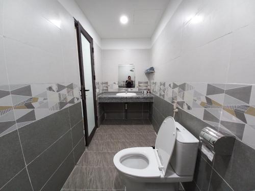 a bathroom with a toilet and a person in a mirror at Cloudy Home - Venuestay in Hanoi