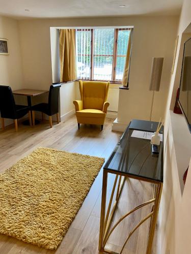 uma sala de estar com uma cadeira amarela e uma mesa em High Hedges Apartment A em Oxford