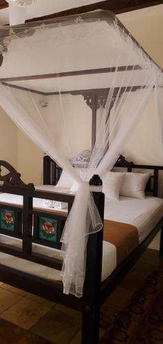 a bedroom with a bed with a canopy at Mangos Villas - Chiara in Kilifi