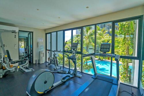 a gym with a view of a swimming pool at Diamond Resort by I Am Home in Bang Tao Beach