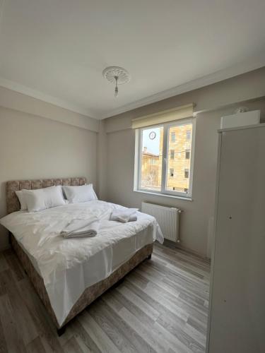 a white bedroom with a bed and a window at Cappadocia 4 Luxury Aparts in Urgup