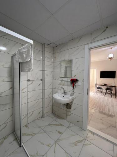 La salle de bains blanche est pourvue d'un lavabo et d'une douche. dans l'établissement Cappadocia 4 Luxury Aparts, à Ürgüp