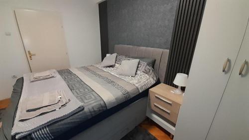 a small bedroom with a bed and a dresser at Kuman Apartments in Kumanovo