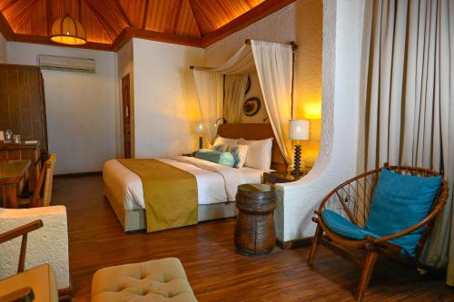 a hotel room with a bed and a chair at Makunudu Island in Makunudhoo