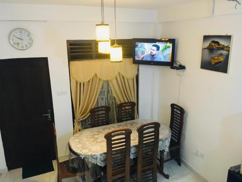 a dining room with a table and a tv at Rochesta Holiday Inn in Badulla