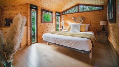 um quarto com uma cama num chalé de madeira em Le Chalet - Les Lodges de Praly em Les Ollières-sur-Eyrieux