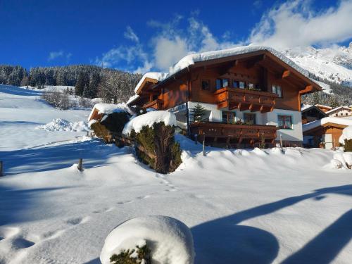 uma cabana de madeira na neve com neve coberta em Aparthaus Winkler em Hinterthal