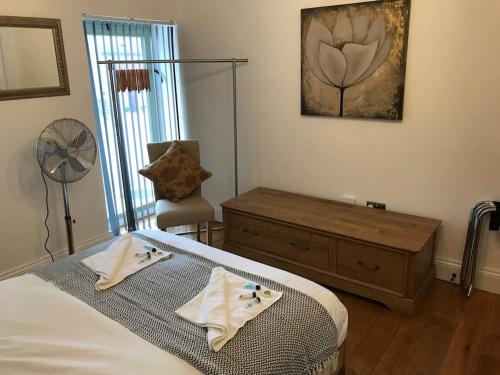 a bedroom with a bed and a dresser and a fan at Stylish 2 Bed Peak District Cottage Barn - Alton Towers, Scarefest, Polar Bears, Chatsworth in Waterfall