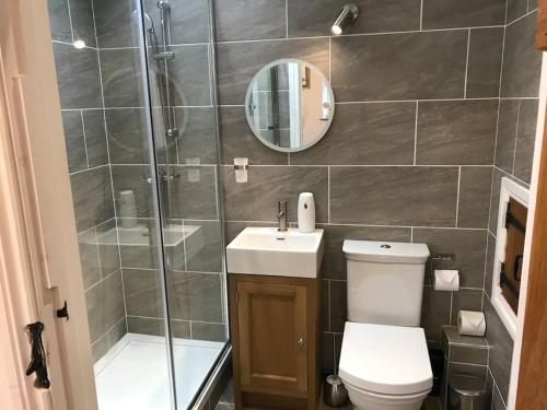 uma casa de banho com um chuveiro, um WC e um lavatório. em 2 Bed Stylish Peak District Cottage Barn Near Alton Towers, Polar Bears, Chatsworth House em Waterfall