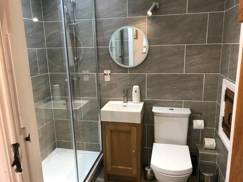 a bathroom with a shower and a toilet and a sink at Stylish 2 Bed Peak District Cottage Barn - Alton Towers, Scarefest, Polar Bears, Chatsworth in Waterfall