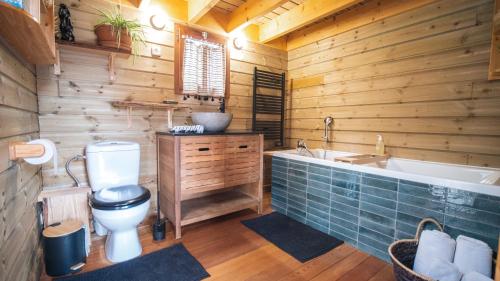 y baño de madera con aseo y bañera. en Le Chalet - Les Lodges de Praly, en Les Ollières-sur-Eyrieux