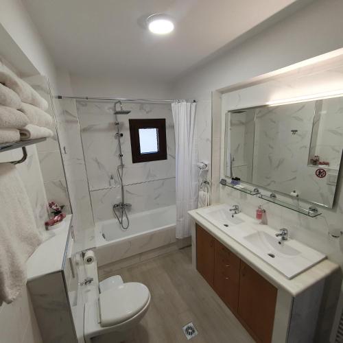a bathroom with a sink and a toilet and a tub at Volos Park Apartments in Volos