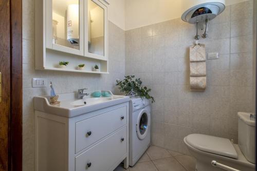 a bathroom with a washing machine and a sink at Attico Castelsardo con vista mare in Castelsardo