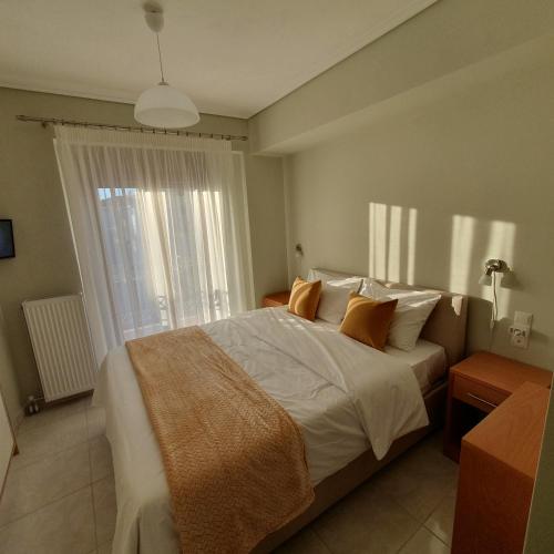 a bedroom with a large bed with orange pillows at Volos Park Apartments in Volos