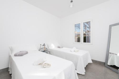 a white room with two tables and a mirror at Cala Rafalino in S'Illot
