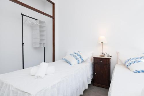 two white beds in a room with a mirror at Cala Rafalino in S'Illot