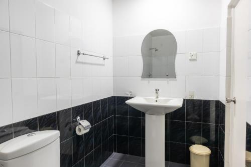 a white bathroom with a sink and a toilet at Homies Place - Bistro in Bandarawela